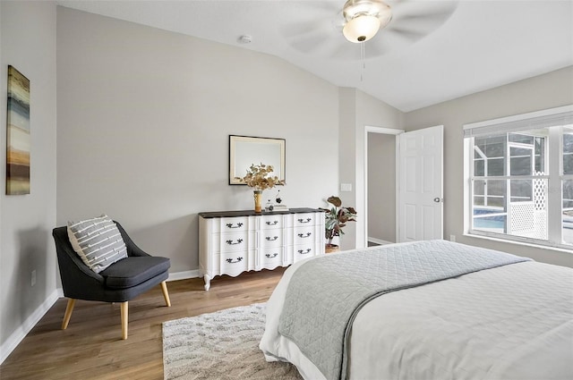 bedroom with hardwood / wood-style flooring, vaulted ceiling, and ceiling fan