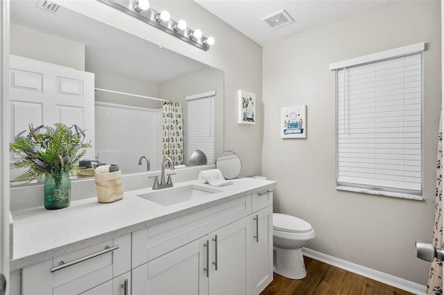 bathroom with a shower with shower curtain, vanity, hardwood / wood-style flooring, and toilet