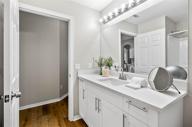 bathroom with a shower, vanity, and hardwood / wood-style flooring