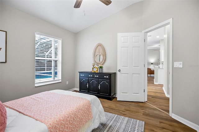 bedroom featuring multiple windows, hardwood / wood-style flooring, ceiling fan, and lofted ceiling