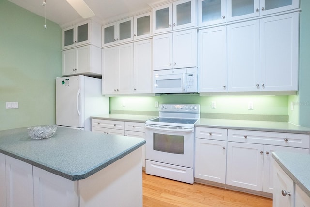 kitchen with white cabinets, light wood-type flooring, and white appliances