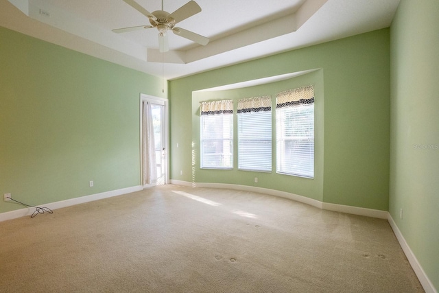 unfurnished room with carpet, a raised ceiling, and ceiling fan