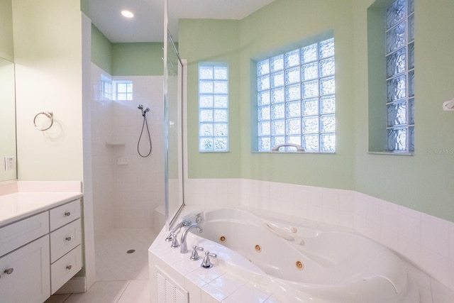 bathroom featuring plus walk in shower, vanity, tile patterned floors, and a wealth of natural light