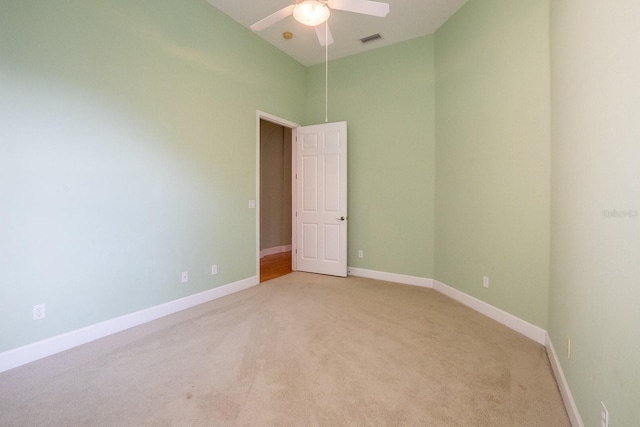 spare room with ceiling fan and light colored carpet