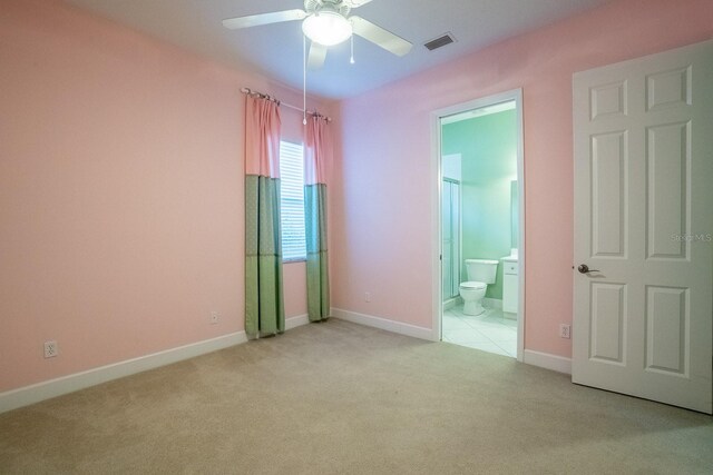 unfurnished bedroom with ensuite bathroom, ceiling fan, and light colored carpet