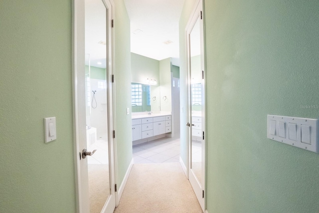 corridor with sink and light colored carpet