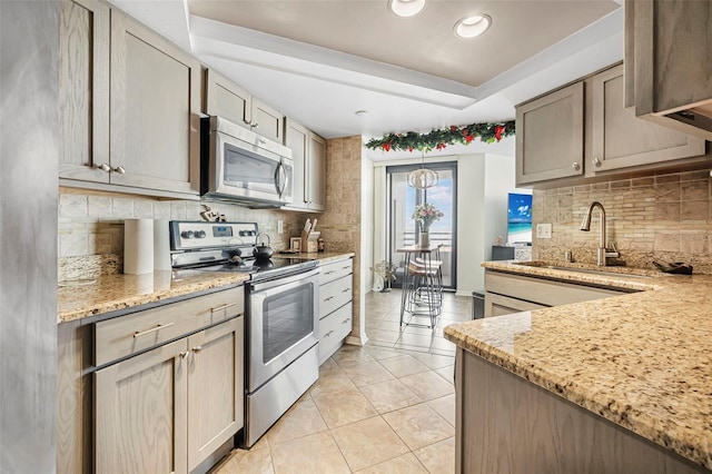 kitchen with sink, appliances with stainless steel finishes, tasteful backsplash, light tile patterned flooring, and light stone counters