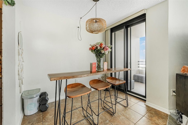 tiled dining area featuring a textured ceiling