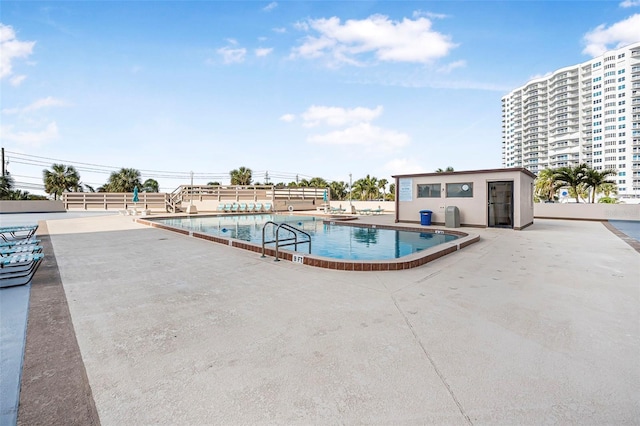 view of swimming pool featuring an outdoor structure and a patio