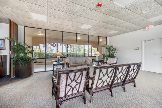 living room featuring a paneled ceiling and carpet