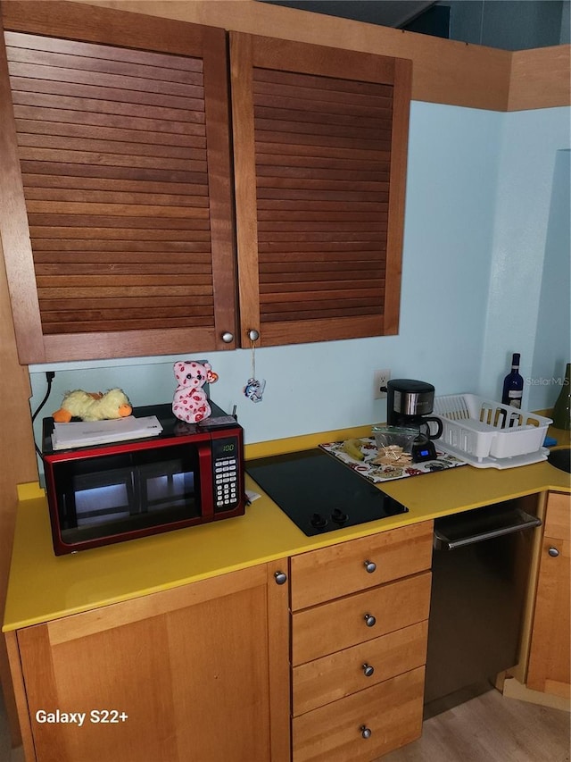 kitchen featuring cooktop, dishwasher, and light hardwood / wood-style floors