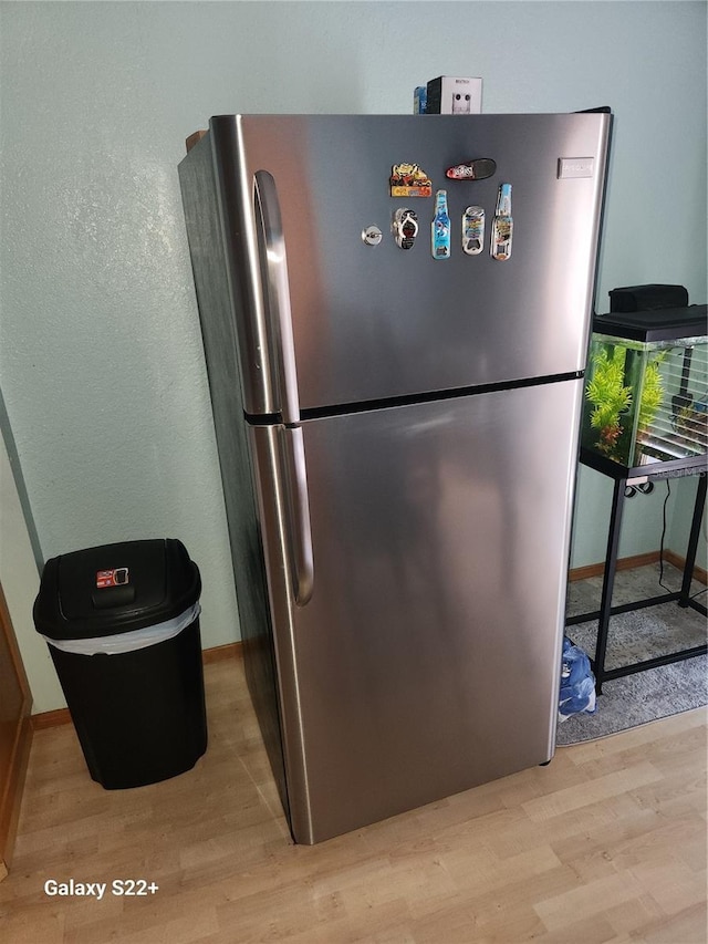 kitchen featuring stainless steel fridge and light hardwood / wood-style floors