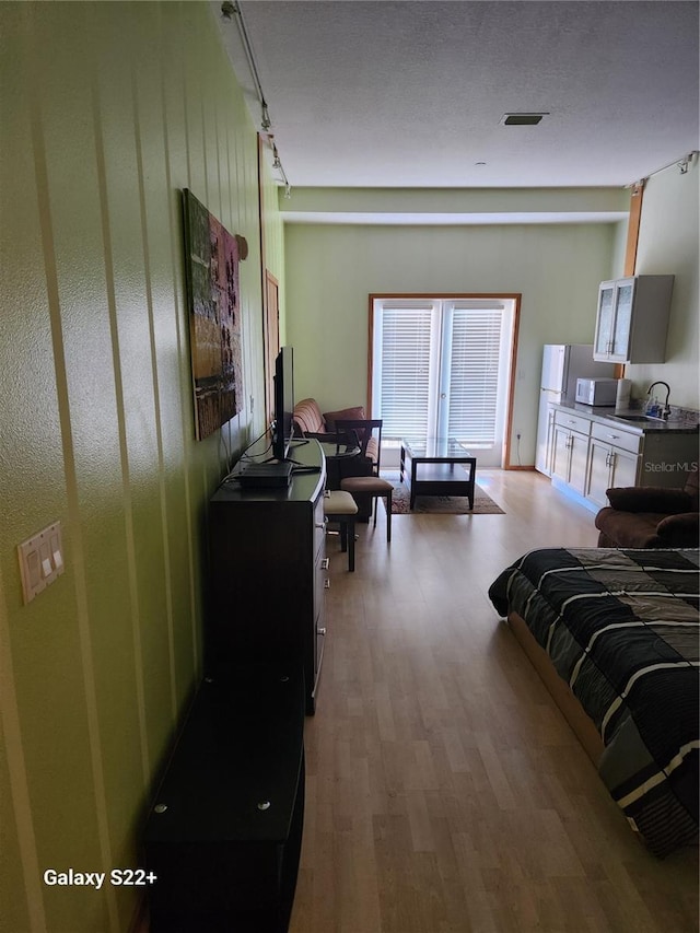 bedroom featuring light hardwood / wood-style flooring and sink