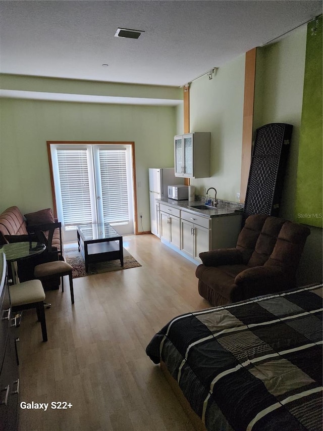 bedroom with light hardwood / wood-style floors and sink