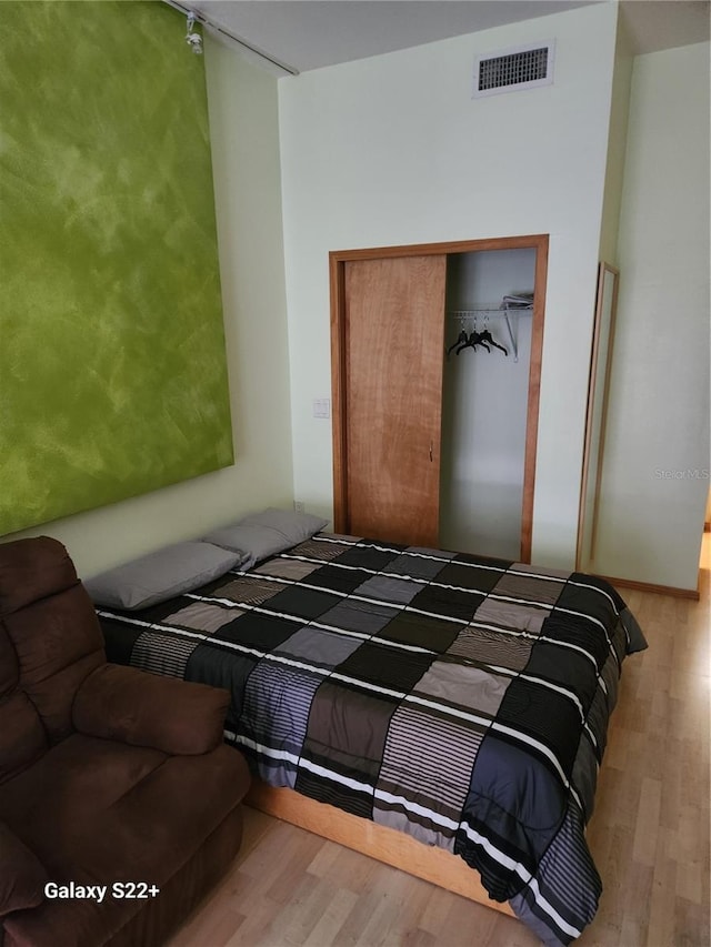 bedroom with wood-type flooring and a closet