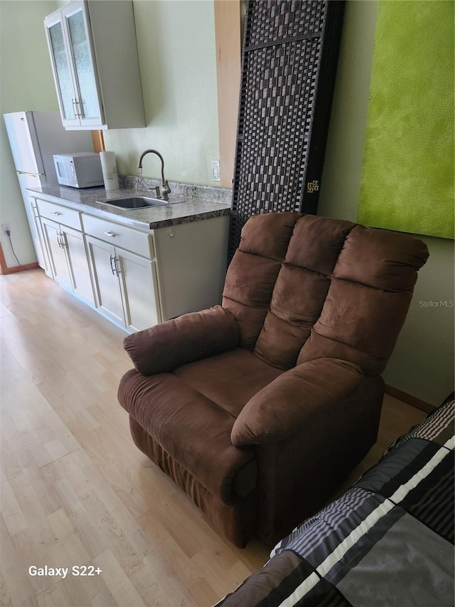 living room with light hardwood / wood-style floors and sink