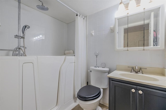 bathroom featuring vanity, toilet, tile walls, and tasteful backsplash