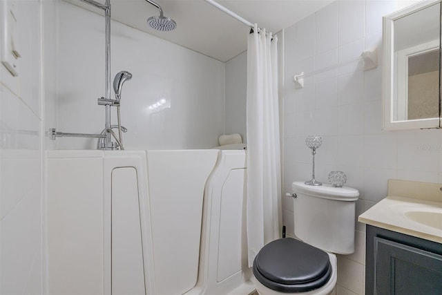 bathroom with a shower with curtain, vanity, toilet, and tile walls