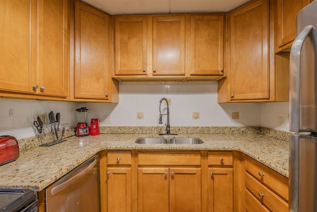 kitchen with backsplash, sink, light stone countertops, and stainless steel appliances