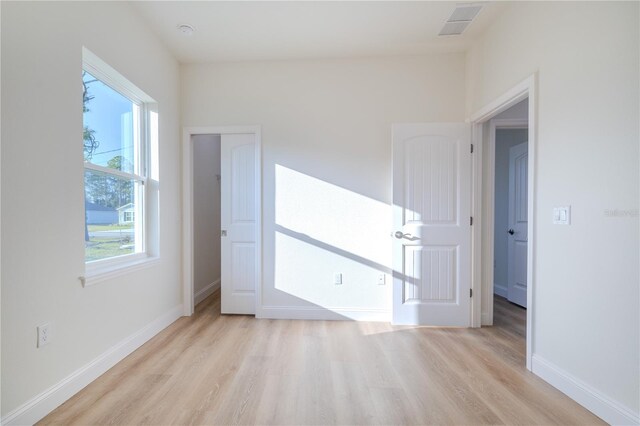 spare room featuring plenty of natural light and light hardwood / wood-style floors