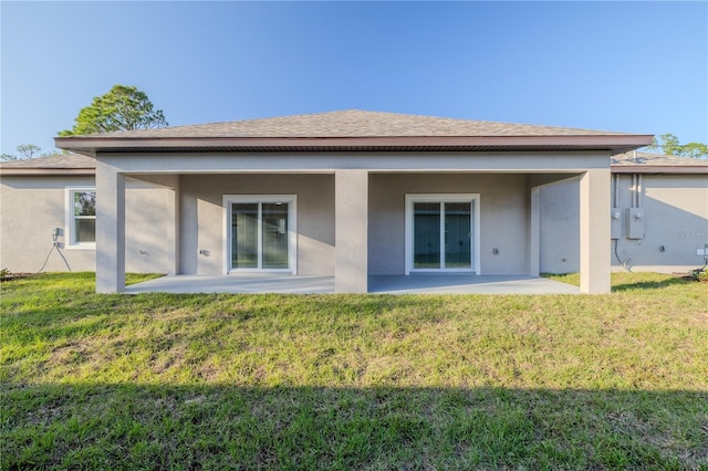 rear view of house featuring a patio area and a yard