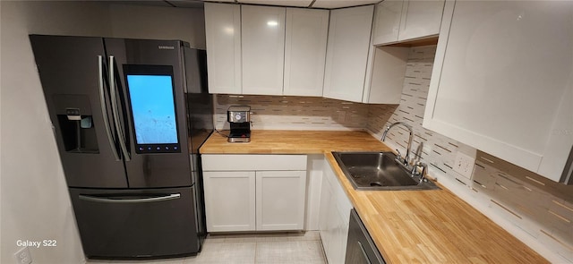 935 N Halifax Ave Unit 602, Daytona Beach, FL 32118 - kitchen featuring white cabinets, appliances with stainless steel finishes, a sink, wood counters, and decorative backsplash