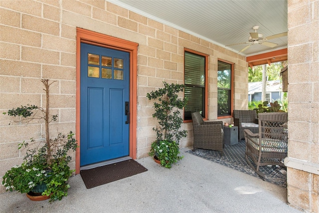 entrance to property with ceiling fan and a porch