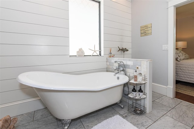 bathroom with a washtub and wood walls