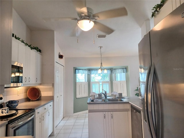 kitchen featuring kitchen peninsula, sink, white cabinetry, and stainless steel appliances