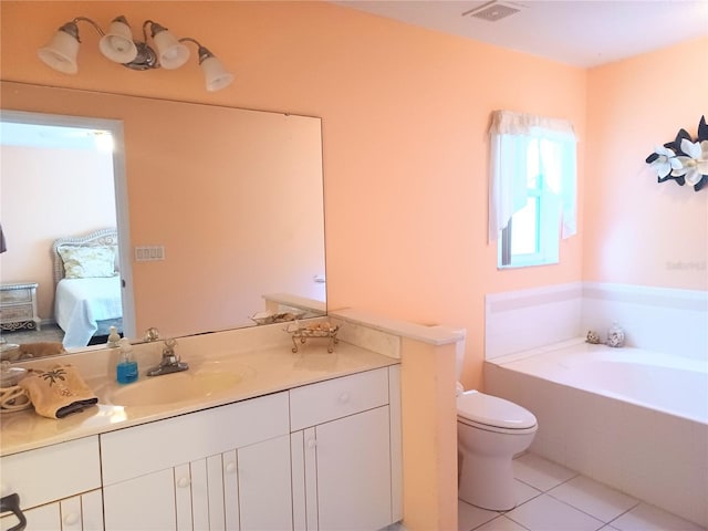 bathroom featuring tile patterned floors, tiled bath, vanity, and toilet