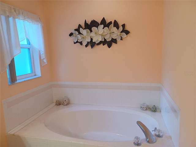 bathroom featuring tiled bath and a healthy amount of sunlight