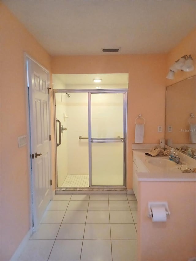 bathroom featuring tile patterned flooring, vanity, and walk in shower