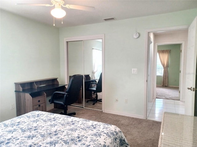 carpeted bedroom with ceiling fan and a closet