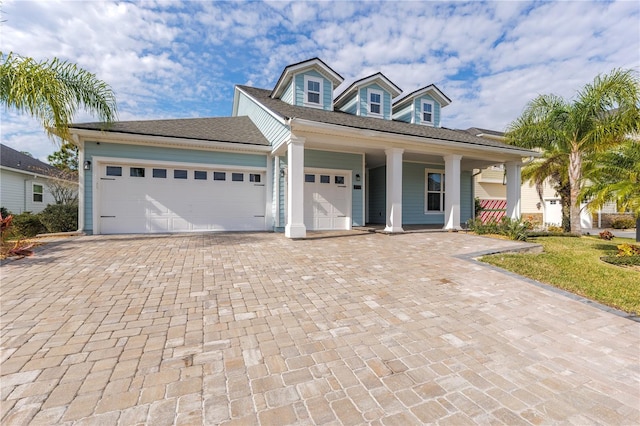 view of front facade featuring an attached garage and decorative driveway