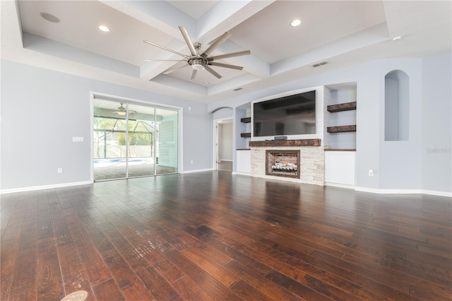 unfurnished living room featuring a fireplace, a ceiling fan, baseboards, hardwood / wood-style floors, and beamed ceiling