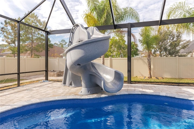 view of pool with glass enclosure, a patio area, a fenced backyard, and a fenced in pool