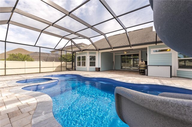 view of swimming pool with a patio, ceiling fan, a lanai, fence, and a pool with connected hot tub