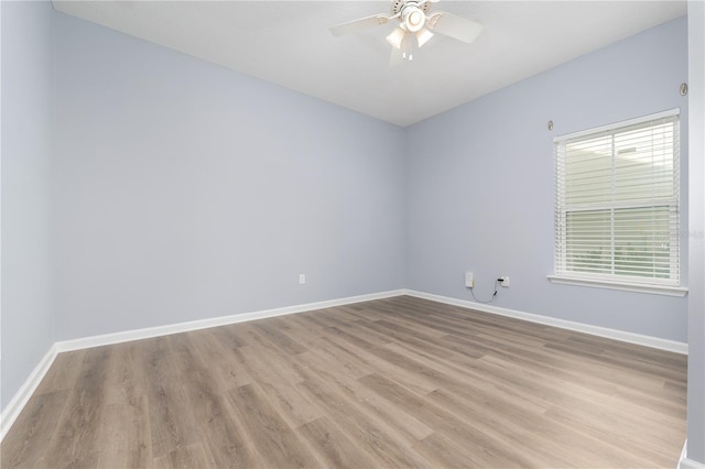 spare room with ceiling fan, light wood-style flooring, and baseboards