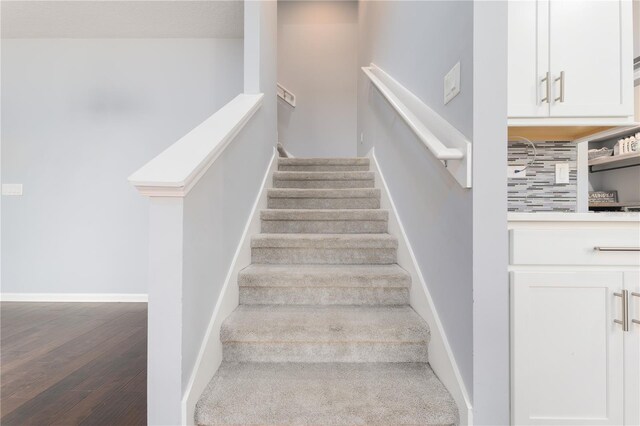 stairs with wood finished floors and baseboards