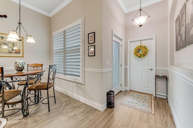 foyer entrance featuring crown molding and light hardwood / wood-style flooring