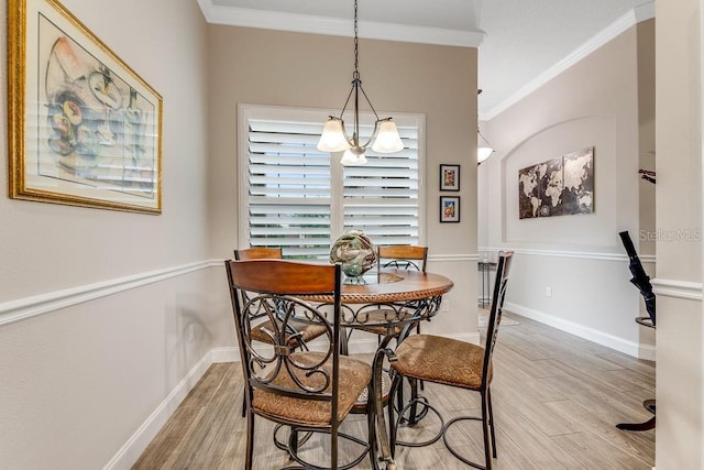 dining room featuring an inviting chandelier, ornamental molding, and hardwood / wood-style flooring