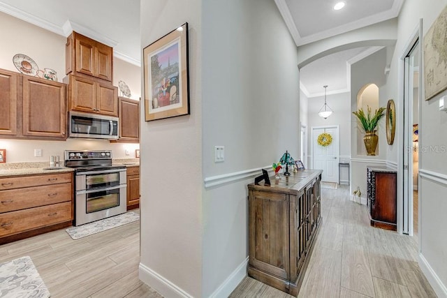 kitchen with appliances with stainless steel finishes, decorative light fixtures, and ornamental molding