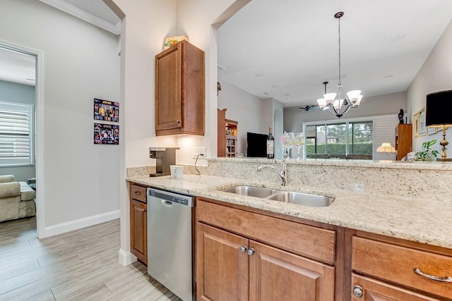 kitchen featuring light stone countertops, sink, light hardwood / wood-style flooring, dishwasher, and hanging light fixtures