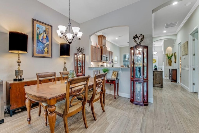 dining space featuring crown molding and a notable chandelier