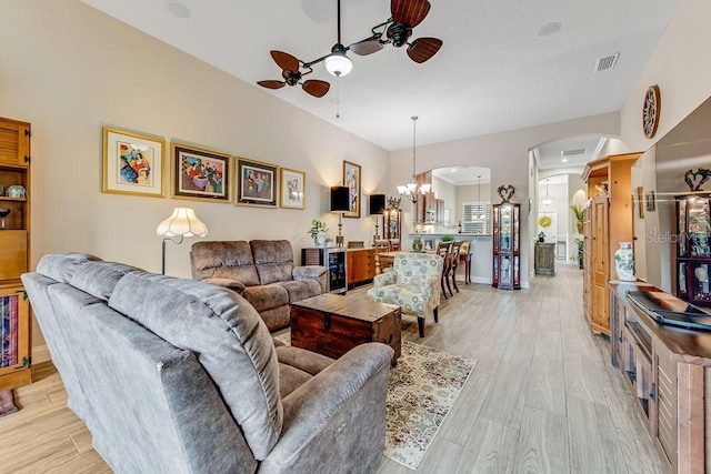 living room with ceiling fan with notable chandelier