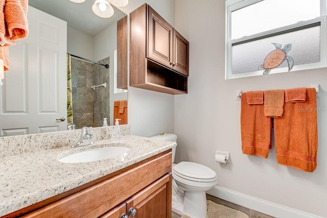 bathroom featuring curtained shower, vanity, and toilet