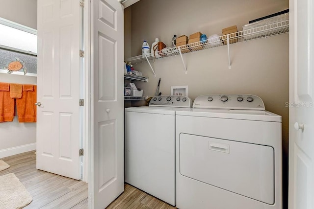 washroom with light wood-type flooring and washing machine and clothes dryer