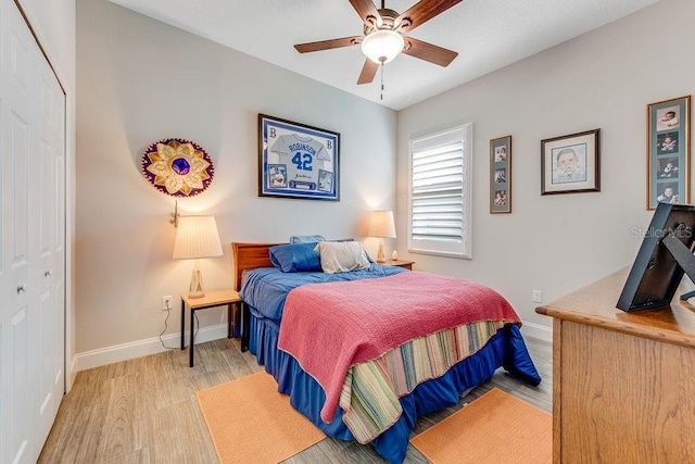 bedroom with light wood-type flooring, a closet, and ceiling fan