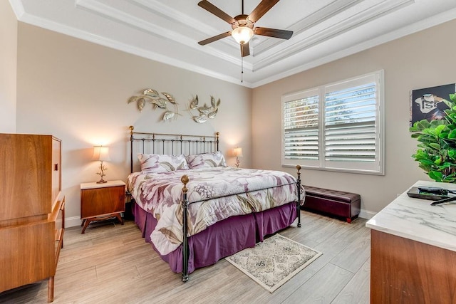 bedroom featuring light hardwood / wood-style floors, a raised ceiling, ceiling fan, and crown molding