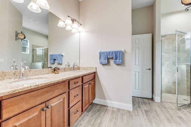 bathroom featuring a shower with door, vanity, and wood-type flooring